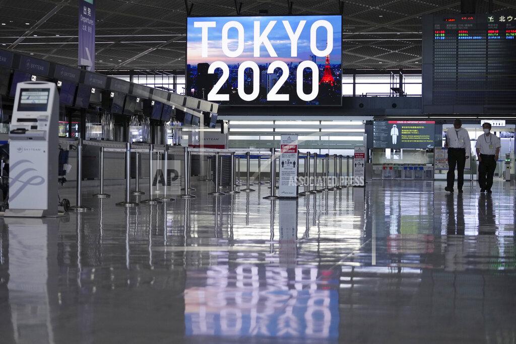 Eugene Hoshiko Staff wearing protective masks to help curb the spread of the coronavirus walk in the empty ticketing area at Narita International Airport Tuesday afternoon, June 1, 2021, in Narita, east of Tokyo. A state of emergency in Tokyo, Osaka and other prefectures was last week extended until June 20 as COVID-19 cases continue to put the medical system under strain. (AP Photo/Eugene Hoshiko)