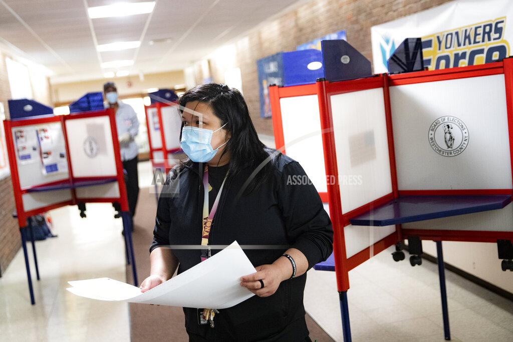 John Minchillo A voter wears a protective mask while casting their vote in New York's primary election at a polling site inside Yonkers Middle/High School, Tuesday, June 23, 2020, in Yonkers, N.Y. (AP Photo/John Minchillo)