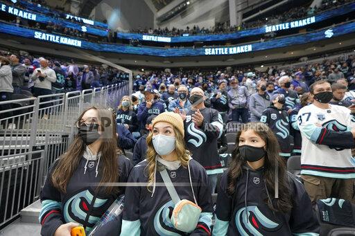Seattle Kraken fans watch in Climate Pledge Arena as players warm up Saturday, Oct. 23, 2021, in Seattle, for the NHL hockey expansion team's home-opener against the Vancouver Canucks. (AP Photo/Ted S. Warren)