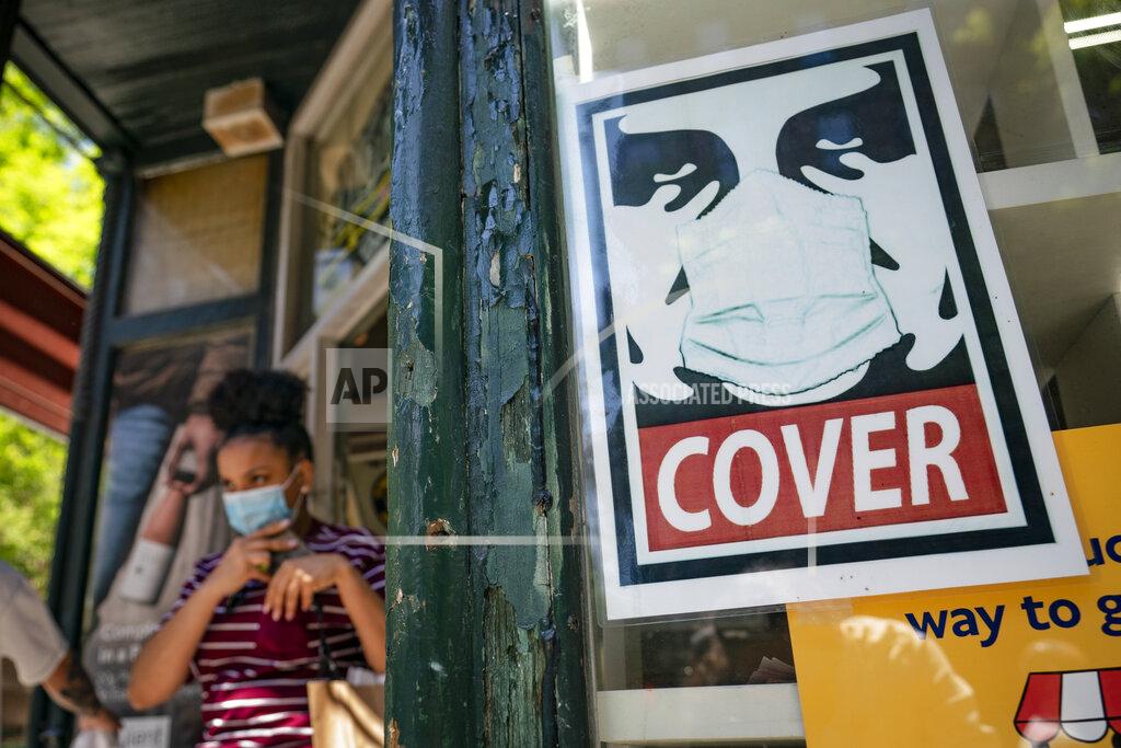 John Minchillo FILE - A customer exits a corner market while wearing a protective mask in the retail shopping district of the SoHo neighborhood of the Manhattan borough of New York, Friday, May 14, 2021. New York eased its mask and social distancing mandates again on Wednesday, May 19, 2021 but people shouldn’t be throwing their face coverings in the garbage just yet. Masks are still required for everyone in many settings. Millions of unvaccinated New Yorkers still have to wear them in most public places. (AP Photo/John Minchillo, file)