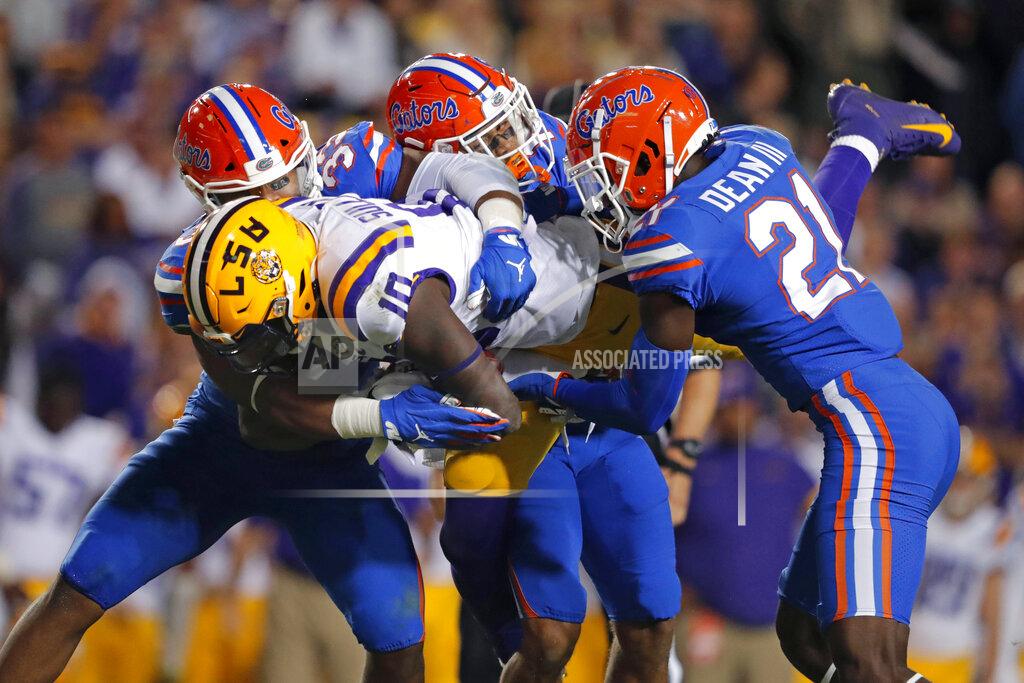 Gerald Herbert Florida linebacker David Reese II, left, defensive back Donovan Stiner and defensive back Trey Dean III (21) upend LSU tight end Stephen Sullivan (10) on a reception in the first half of an NCAA college football game in Baton Rouge, La., Saturday, Oct. 12, 2019. (AP Photo/Gerald Herbert)