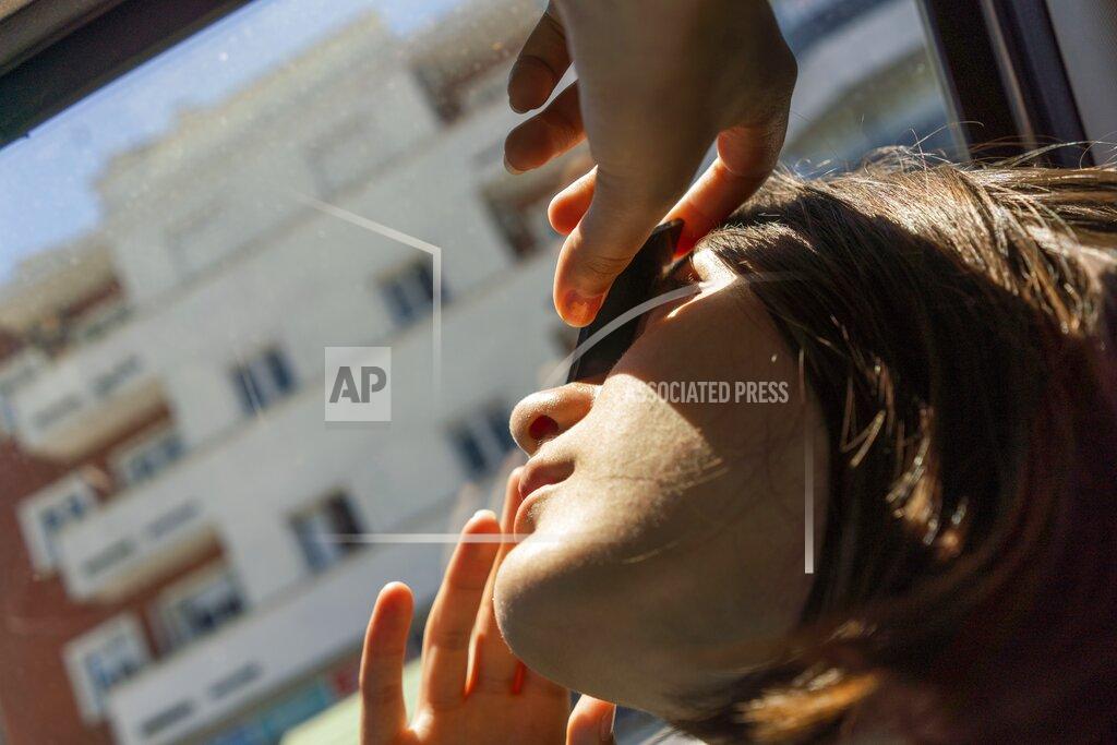Matilde Campodonico A girl looks at a partial solar eclipse through a filtered piece of glass from Montevideo, Uruguay, Monday, Dec. 14, 2020. A total solar eclipse was visible from Chile and the northern Patagonia region of Argentina, and as a partial solar eclipse in Bolivia, Brazil, Ecuador, Paraguay, Peru and Uruguay. (AP Photo/Matilde Campodonico)