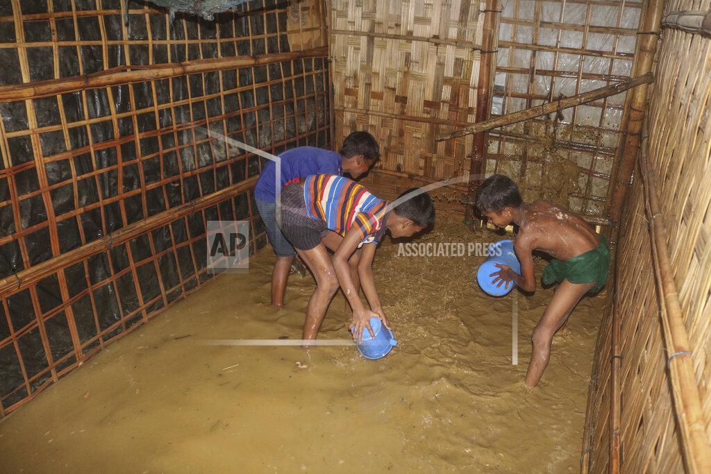 Shafiqur Rahman Rohingya refugee children try to pour away flood water from their homes at the Rohingya refugee camp in Kutupalong, Bangladesh, Wednesday, July 28, 2021. Days of heavy rains have brought thousands of shelters in various Rohingya refugee camps in Southern Bangladesh under water, rendering thousands of refugees homeless. (AP Photo/ Shafiqur Rahman)