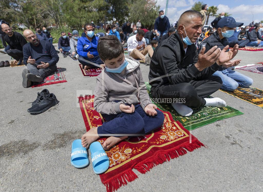 Nasser Nasser Palestinians practice outdoor social distancing while attending the last Friday prayers ahead of the upcoming Muslim fasting month of Ramadan, at a parking lot in the West Bank city of Ramallah, Friday, April 9, 2021. The West Bank welcomes Ramadan this year while under lockdown measures, due to a surge in COVID-19 cases, that includes restrictions on mosques indoor mass prayers. (AP Photo/Nasser Nasser)
