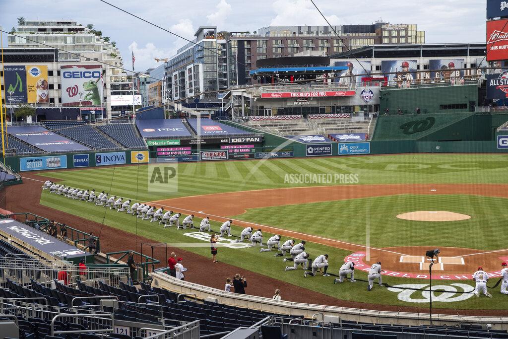 Alex Brandon Members of the New York Yankees and Washington Nationals kneel and hold a piece of black fabric before an opening day baseball game at Nationals Park, Thursday, July 23, 2020, in Washington. (AP Photo/Alex Brandon)