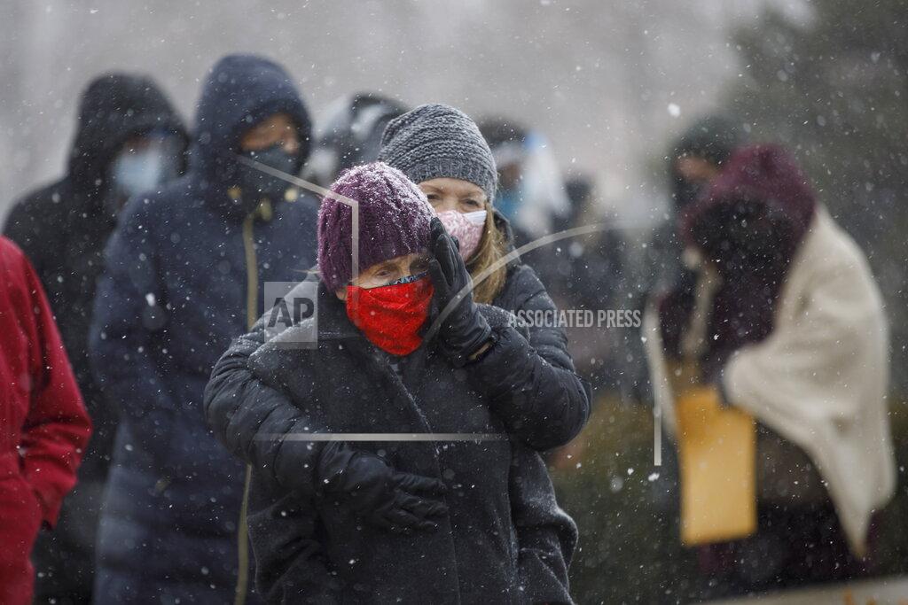 Cole Burston Kelly Steptoe embraces her mother Patricia Nind as they wait in line for a COVID-19 vaccination at a mass vaccination site for York Region residents 80 years and older, in Richmond Hill, Ontario, on Monday, March 1, 2021. (Cole Burston/The Canadian Press via AP)