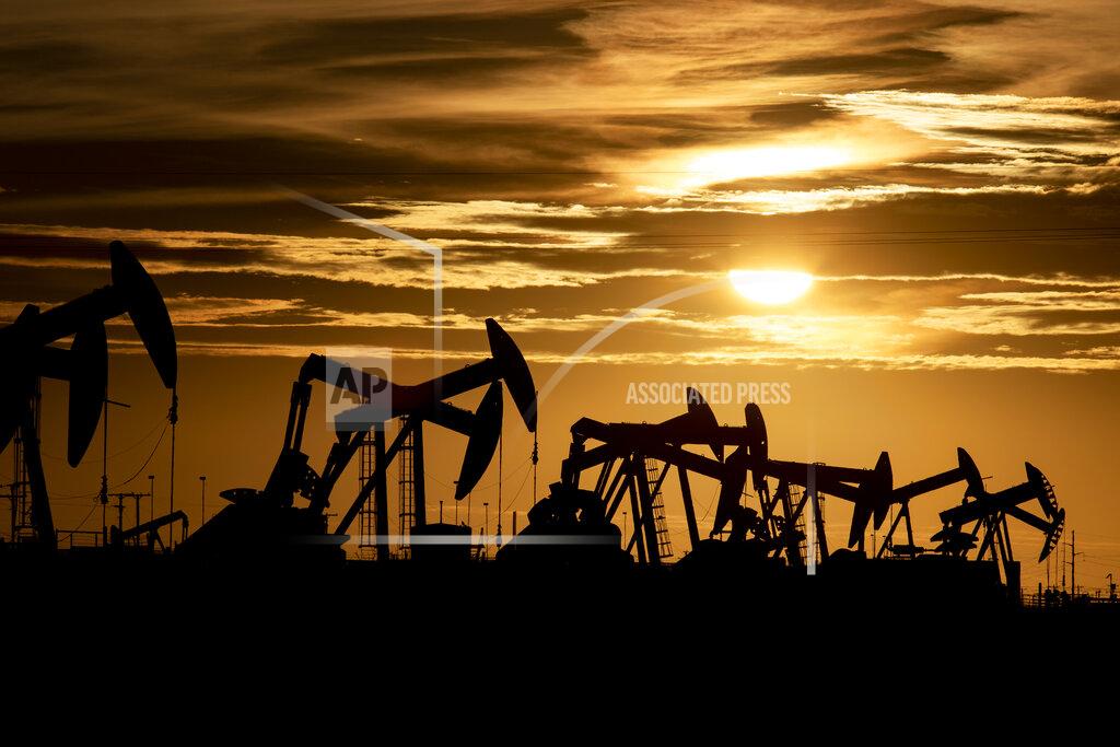 FILE - In this Tuesday, Feb. 2, 2020, file photo, pump jacks operate in an oilfield as the sun begins to set on the horizon in Midland, Texas. Energy companies spent the first quarter of 2021 recharging after a draining year amid the coronavirus pandemic. (Jacob Ford/Odessa American via AP, File)