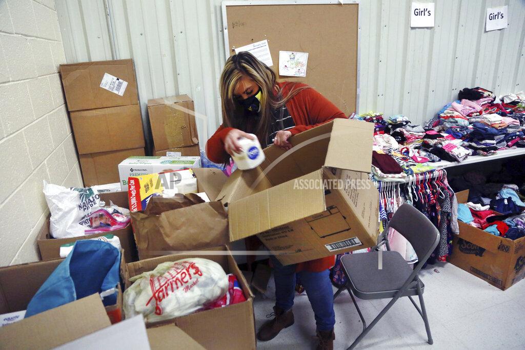 Cedar Attanasio Social worker Victoria Dominguez collects supplies at Cuba High School to deliver along a rural school bus route outside Cuba, N.M., Oct. 19, 2020. The switch to remote learning in rural New Mexico has left some students profoundly isolated — cut off from others and the grid by sheer distance. The school system is sending school buses to students’ far-flung homes to bring them assignments, meals and a little human contact. (AP Photo/Cedar Attanasio)