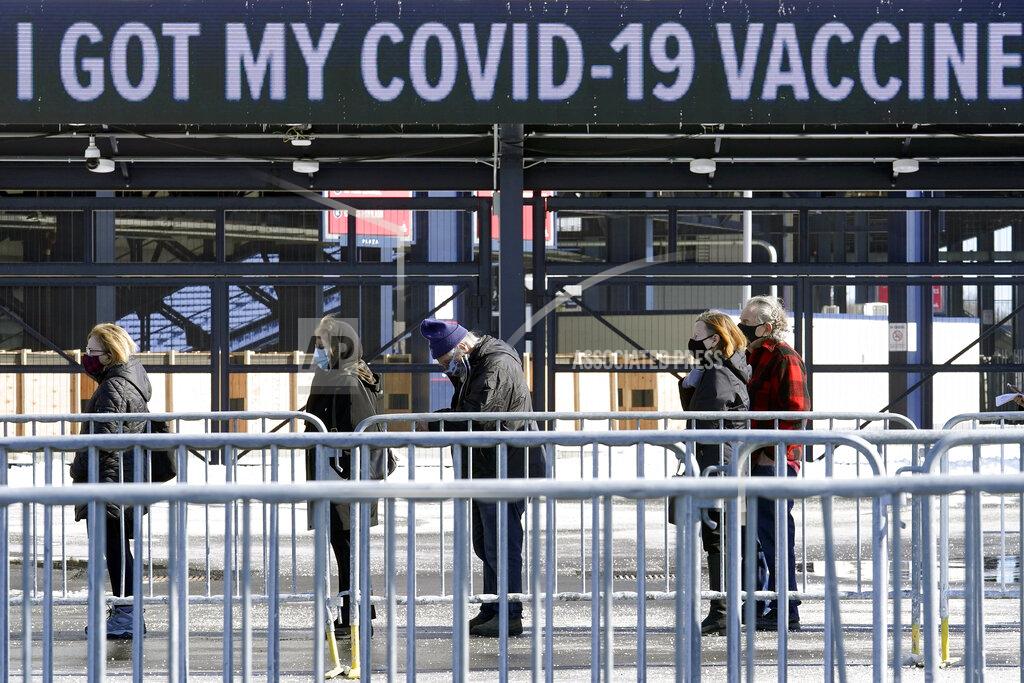 Steven Senne People wait in a socially distanced line to get their COVID-19 vaccinations at Gillette Stadium, Monday, Feb. 8, 2021, in Foxborough, Mass. (AP Photo/Steven Senne)