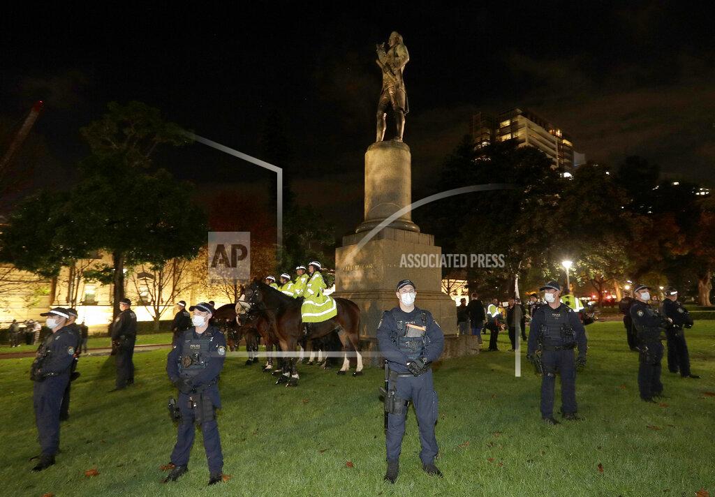 Rick Rycroft Police guard a statue of British explorer James Cook as protesters gather in Sydney, Friday, June 12, 2020, to support U.S. protests over the death of George Floyd. Hundreds of police disrupted plans for a Black Lives Matter rally but protest organizers have vowed that other rallies will continue around Australia over the weekend despite warnings of the pandemic risk. (AP Photo/Rick Rycroft)