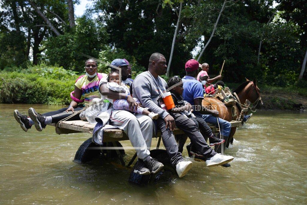 Fernando Vergara Migrants cross the Acandi River on a horse cart in Acandi, Colombia, Tuesday, Sept. 14, 2021. The migrants, following a well-beaten, multi-nation journey towards the U.S., will continue their journey through the jungle known as the Darien Gap. (AP Photo/Fernando Vergara)