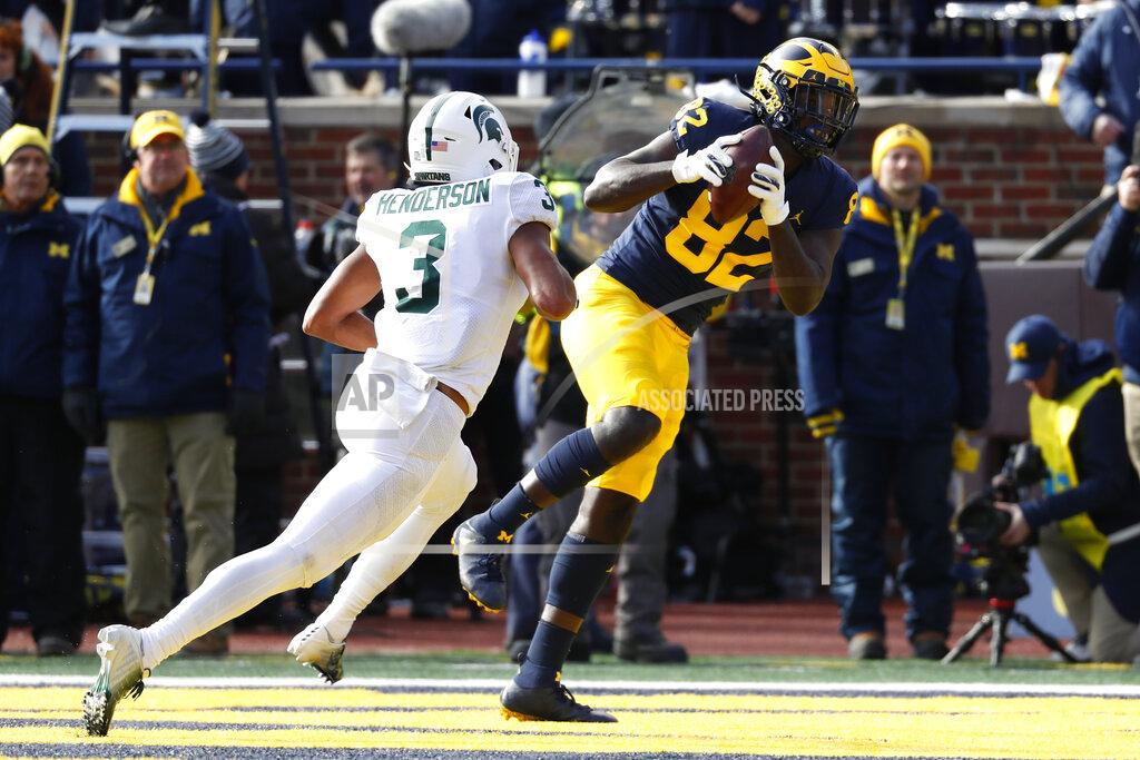 Paul Sancya Michigan tight end Nick Eubanks (82) catches a 5-yard touchdown pass as Michigan State safety Xavier Henderson (3) defends in the first half of an NCAA college football game in Ann Arbor, Mich., Saturday, Nov. 16, 2019. (AP Photo/Paul Sancya)