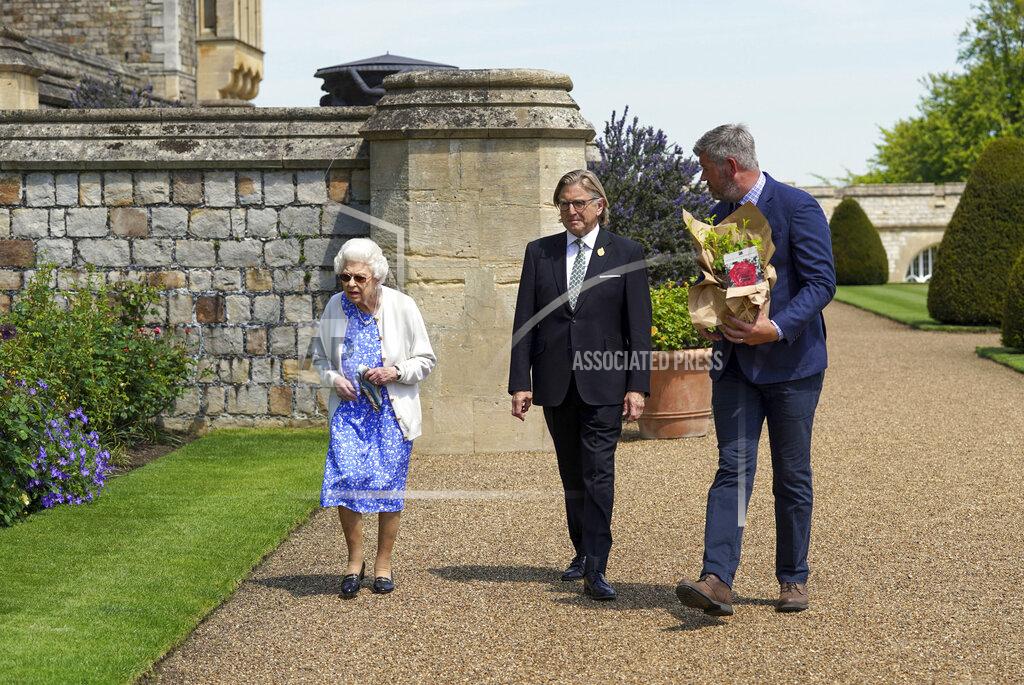 Steve Parsons Britain's Queen Elizabeth II looks at flower beds after receiving a Duke of Edinburgh rose, given to her by Keith Weed, centre, President of the Royal Horticultural Society, at Windsor Castle, England, Wednesday June 9, 2021. The newly bred deep pink commemorative rose has officially been named in memory of the late Prince Philip Duke of Edinburgh. A royalty from the sale of each rose will go to The Duke of Edinburgh's Award Living Legacy Fund to support young people taking part in the Duke of Edinburgh Award scheme. (Steve Parsons/Pool via AP)