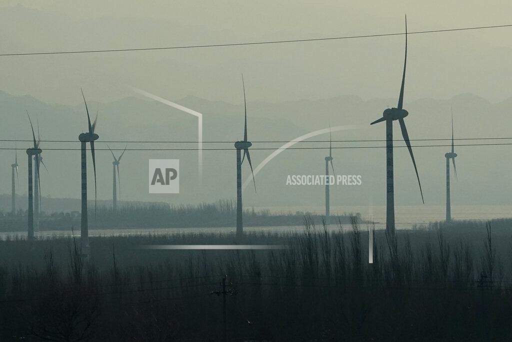 Ng Han Guan Windmills are seen from a high speed train traveling from Beijing to neighboring Zhangjiakou in northwestern China's Hebei province on Dec. 15, 2020. Expectations are high that the 14th five-year plan will align domestic policies with international pledges on climate change. Chinese President Xi Jinping made a surprise pledge at a United Nations meeting in September that China would go carbon neutral by 2060. (AP Photo/Ng Han Guan)