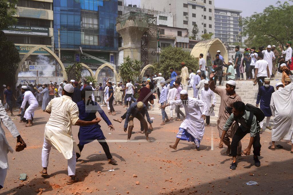 Mahmud Hossain Opu Two factions of protestors clash after Friday prayers at Baitul Mokarram mosque in Dhaka, Bangladesh, Friday, March 26, 2021. Witnesses said violent clashes broke out after one faction of protesters began waving their shoes as a sign of disrespect to Indian Prime Minister Narendra Modi, and another group tried to stop them. Local media said the protesters who tried to stop the shoe-waving are aligned with the ruling Awami League party. The party criticized the other protest faction for attempting to create chaos in the country during Modi’s visit. (AP Photo/Mahmud Hossain Opu)