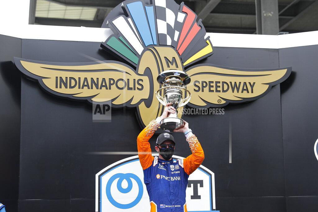 Darron Cummings Race driver Scott Dixon, of New Zealand, celebrates with the trophy after winning the IndyCar auto race at Indianapolis Motor Speedway in Indianapolis, Saturday, July 4, 2020. (AP Photo/Darron Cummings)