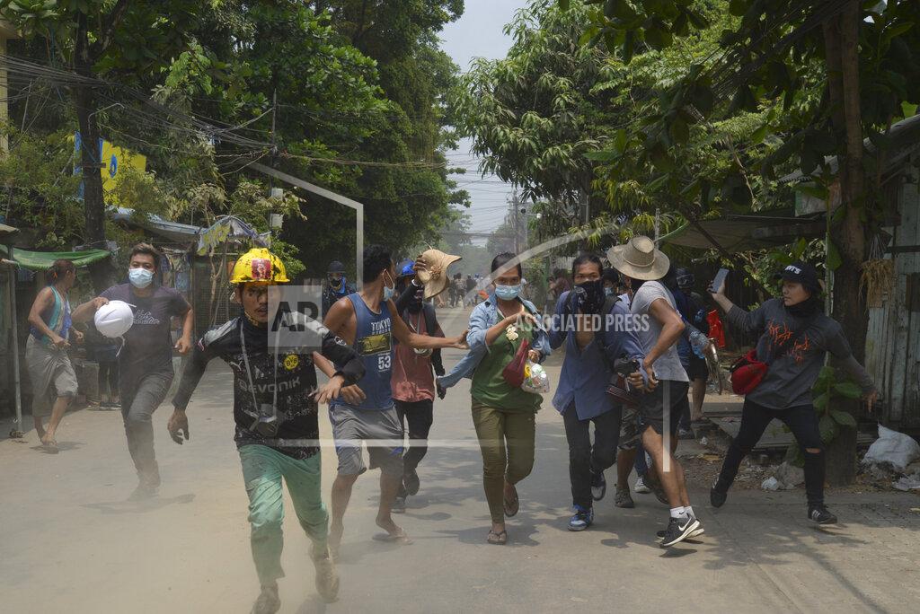Uncredited Anti-coup protesters run to avoid the military during a demonstration in Yangon, Myanmar on Tuesday March 30, 2021. (AP Photo)