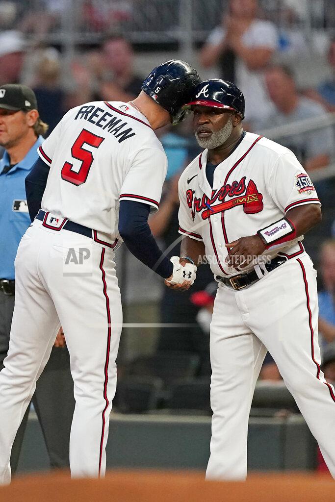 John Bazemore Atlanta Braves first baseman Freddie Freeman (5) touches helmets with first base coach Eric Young Sr. (2) after an RBI single in the first inning of a baseball game against the Colorado Rockies Tuesday, Sept. 14, 2021, in Atlanta. (AP Photo/John Bazemore)