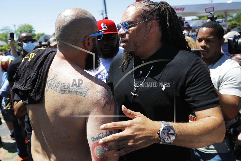 Julio Cortez FILE - In this Wednesday, June 3, 2020 file photo, The Reverend Greg Drumwright, right, greets people at the memorial site for Greg Floyd in Minneapolis. Greg Drumwright, a minister at the Citadel Church & Campus Ministries, helped organize a group of Black fans to attend the NASCAR race at Talladega and support driver Bubba Wallace. Drumwright now hopes he can become an advocate of change for NASCAR.(AP Photo/Julio Cortez, File)
