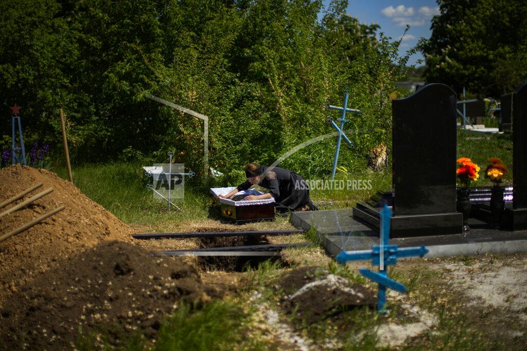 Francisco Seco Iuliia Loseva cries over the coffin of her husband Volodymyr Losev, 38, during his funeral at a cemetery in Zorya Truda, Odesa region, Ukraine, Monday, May 16, 2022. Volodymyr Losev, a Ukrainian volunteer soldier, was killed on May 7 when the military vehicle he was driving ran over a mine in eastern Ukraine. (AP Photo/Francisco Seco)