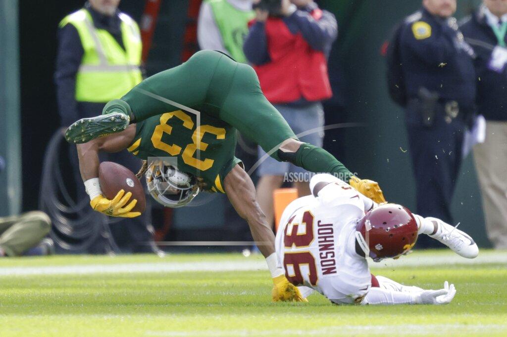 Matt Ludtke Green Bay Packers' Aaron Jones is tripped up by Washington Football Team Danny Johnson during the first half of an NFL football game Sunday, Oct. 24, 2021, in Green Bay, Wis. (AP Photo/Matt Ludtke)