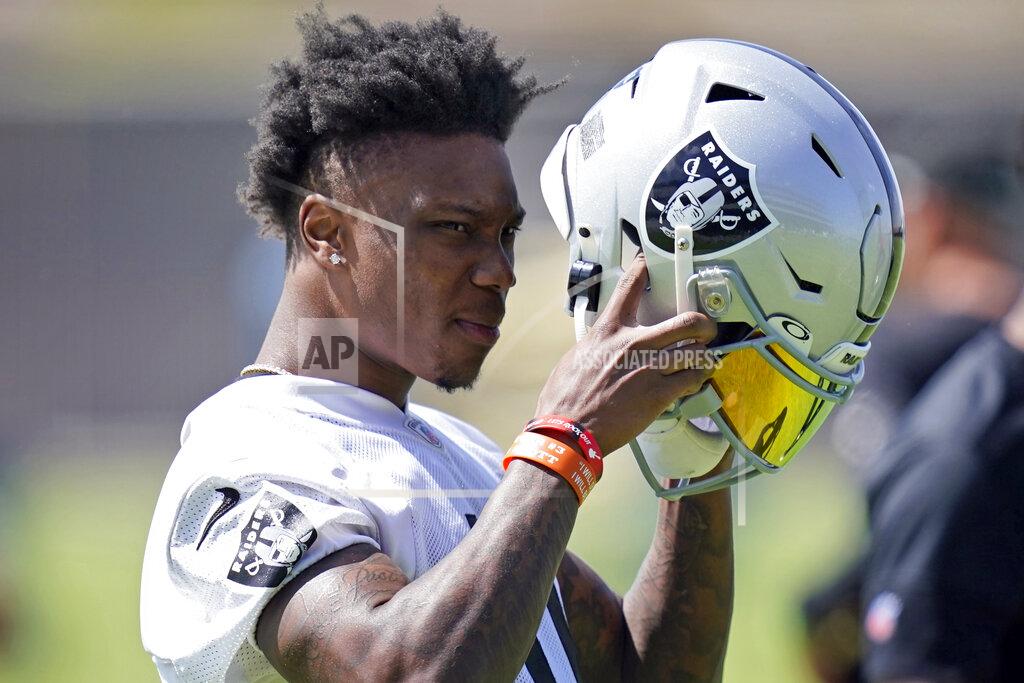 John Locher Las Vegas Raiders wide receiver Henry Ruggs III (11) puts on his helmet during NFL football practice, Wednesday, June 2, 2021, in Henderson, Nev. (AP Photo/John Locher)