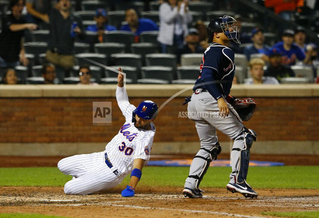 Noah K. Murray New York Mets Michael Conforto, left, scores against the Atlanta Braves during the seventh inning of a baseball game Wednesday, June 23, 2021, in New York. (AP Photo/Noah K. Murray)