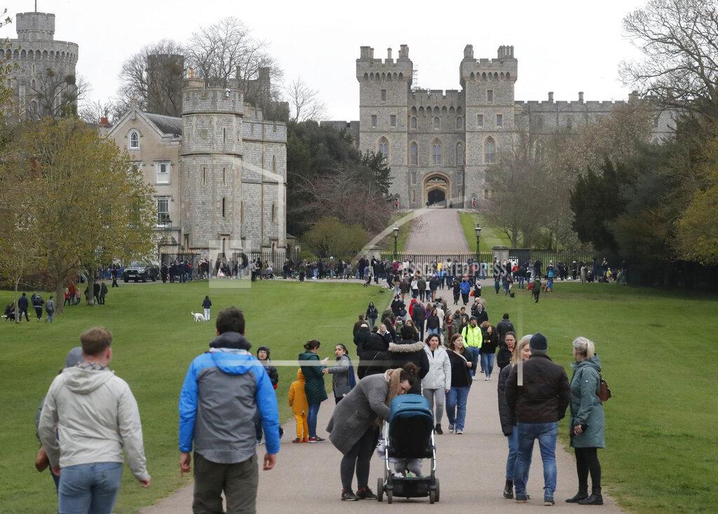 Frank Augstein People stroll on The Long Walk towards Windsor Castle in Windsor, England, Saturday, April 10, 2021. Britain's Prince Philip, the irascible and tough-minded husband of Queen Elizabeth II who spent more than seven decades supporting his wife in a role that mostly defined his life, died on Friday. (AP Photo/Frank Augstein)