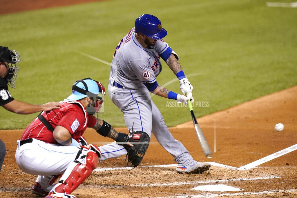 Lynne Sladky New York Mets' Tomas Nido hits a double to score Dominic Smith during the fourth inning of a baseball game against the Miami Marlins, Friday, May 21, 2021, in Miami. At left is Marlins catcher Sandy Leon. (AP Photo/Lynne Sladky)