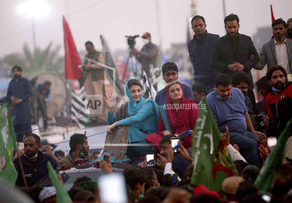 Maryam Nawaz Sharif, center, in blue dress, a leader of the Pakistan Democratic Movement, an alliance of opposition parties, waves to her supporter during an anti-government rally, in Multan, Pakistan, Monday, Nov. 30, 2020. Despite a government ban and arrests of hundreds of activists, Pakistani opposition supporters rallied in a central city on Monday, calling on Prime Minister Imran Khan to resign over alleged bad governance and incompetence. (AP Photo/Asim Tanveer)