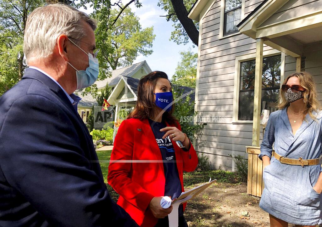 John Flesher Michigan Gov. Gretchen Whitmer, center, and legislative candidate Dan O'Neil, left greet a voter in Traverse City, Mich., Oct. 9, 2020. Whitmer visited the area the day after police announced a foiled plot to kidnap the governor. (AP Photo/John Flesher)