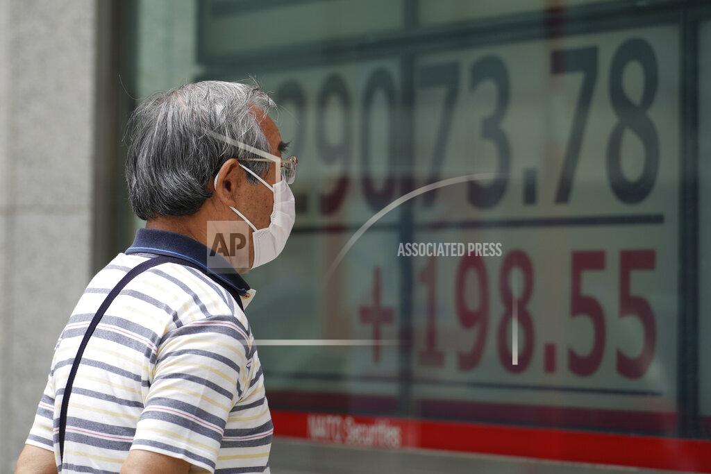 Eugene Hoshiko A man wearing a protective mask looks at an electronic stock board showing Japan's Nikkei 225 index at a securities firm Friday, June 25, 2021, in Tokyo. Asian shares are rising, buoyed by the rally on Wall Street that came after President Joe Biden announced a bipartisan deal on infrastructure spending. (AP Photo/Eugene Hoshiko)