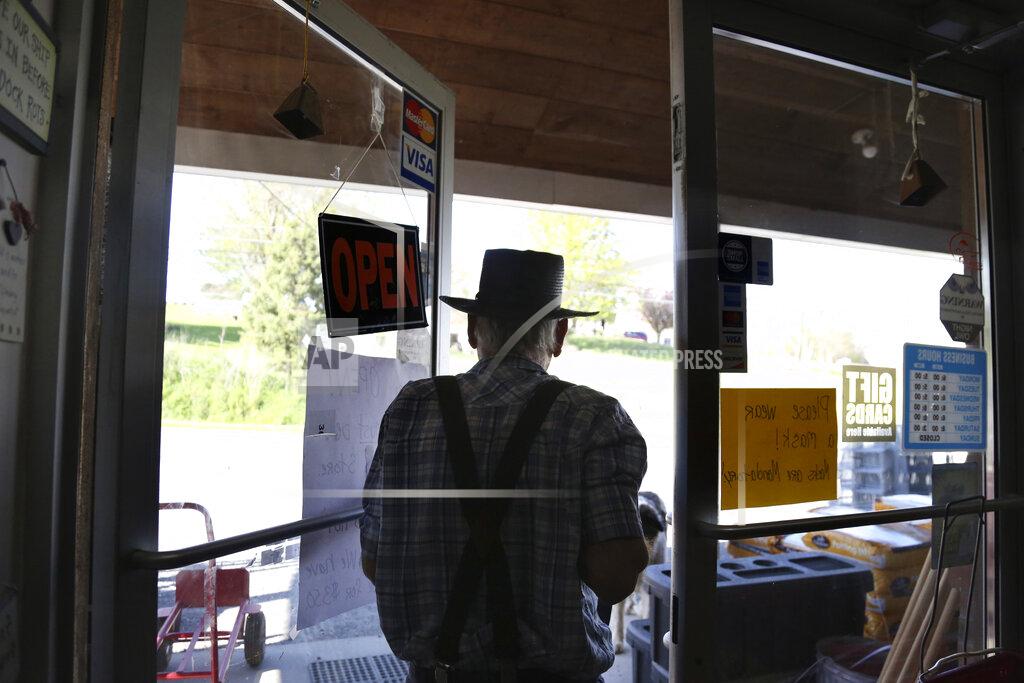 Jessie Wardarski In this Monday, May 4, 2020, photo, Aaron Hurst, owner of AAA Farm Supply and member of the Old Order Groffdale Conference Mennonite Church closes his business for the day in Terre Hill, Pa. Hurst kept his hardware and animal food supply store open through the coronavirus outbreak by taking precautions such as porch pick-up service and mandatory masks. (AP Photo/Jessie Wardarski)