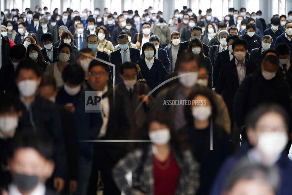 Eugene Hoshiko FILE - In this April 27, 2020, file photo, a station passageway is crowded with commuters wearing face mask in Tokyo. Under Japan's coronavirus state of emergency, people have been asked to stay home. Many are not. Some still have to commute to their jobs despite risks of infection, while others are dining out, picnicking in parks and crowding into grocery stores with scant regard for social distancing. (AP Photo/Eugene Hoshiko, File)
