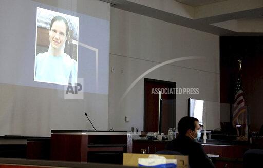 Mark Gooch, 22, sits below an image of Sasha Krause shown on a screen during his trial at the Coconino County Superior Court in Flagstaff, Ariz., on Friday, Sept. 24, 2021. Gooch is charged with first-degree murder in Krause's death in early 2020. (Jake Bacon/Arizona Daily Sun via AP)