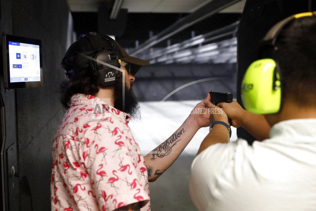 Shafkat Anowar Firearms trainer Kevin Burke, left, instructs new gun owner Troy Deguzman during a shooting session at Maxon Shooter's Supplies and Indoor Range, Friday, April 30, 2021, in Des Plaines, Ill. After a year of pandemic lockdowns, mass shootings are back, but the guns never went away. As the U.S. inches toward a post-pandemic future, guns are arguably more present in the American psyche and more deeply embedded in American discourse than ever before. The past year's anxiety and loss fueled a rise in gun ownership across political and socio-economic lines. (AP Photo/Shafkat Anowar)