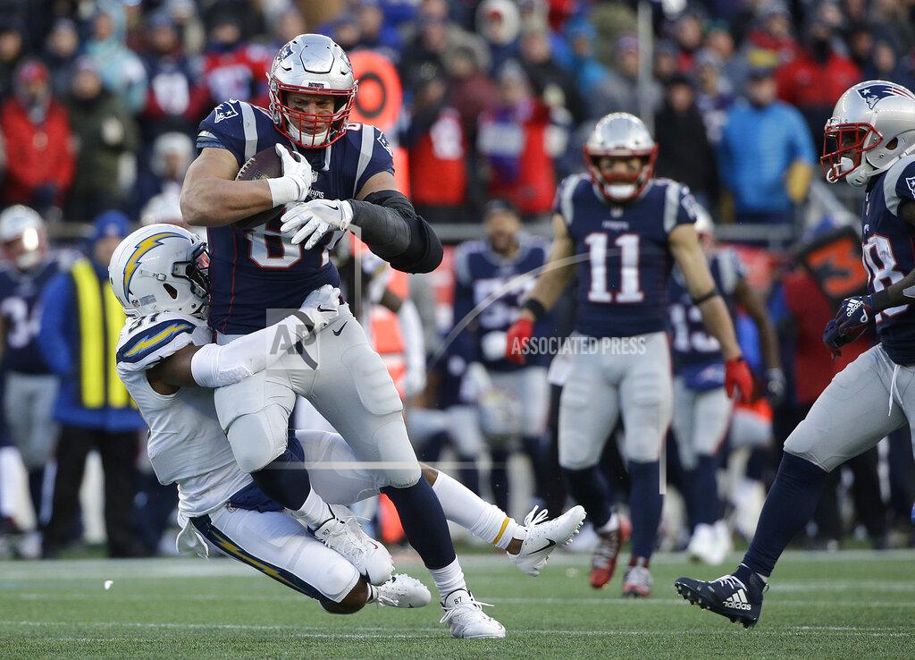 Steven Senne New England Patriots tight end Rob Gronkowski is tackled by Los Angeles Chargers defensive back Adrian Phillips after catching a pass during the second half of an NFL divisional playoff football game, Sunday, Jan. 13, 2019, in Foxborough, Mass. (AP Photo/Steven Senne)