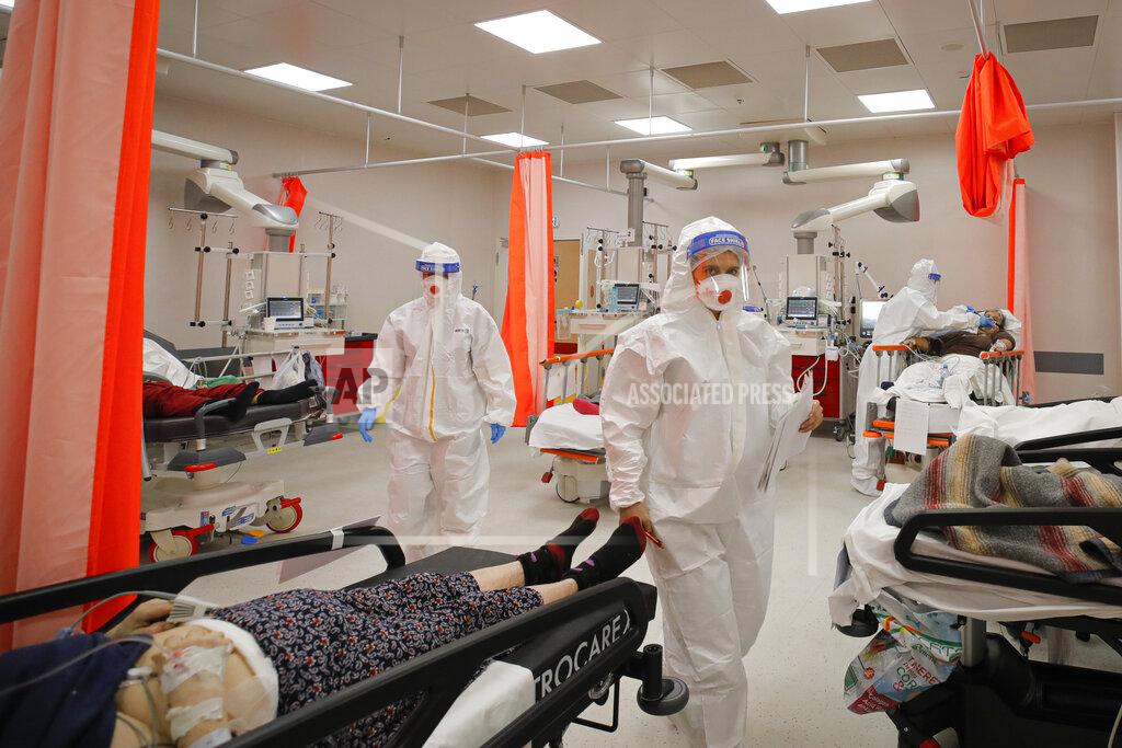 Andreea Alexandru Patients lie on beds in the emergency room, turned into a CODIV-19 unit due the high number of cases, at the Bagdasar-Arseni hospital in Bucharest, Romania, Tuesday, Oct. 12, 2021. Romania reported on Tuesday nearly 17,000 new COVID-19 infections and 442 deaths, the highest number of coronavirus infections and deaths in a day since the pandemic started, as the nation's health care system struggles to cope with an acute surge of new cases.(AP Photo/Andreea Alexandru)