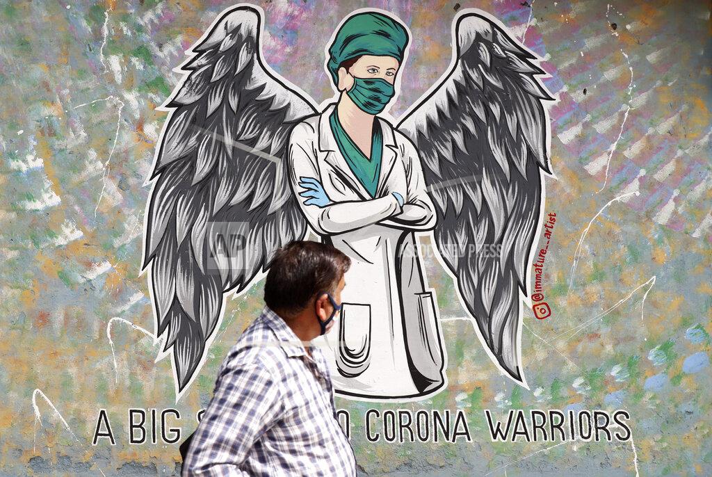 Amit Sharma A man walks past a graffiti saluting frontline workers in the fight against the coronavirus pandemic in New Delhi, India, Wednesday, June 9, 2021. (AP Photo/Amit Sharma)