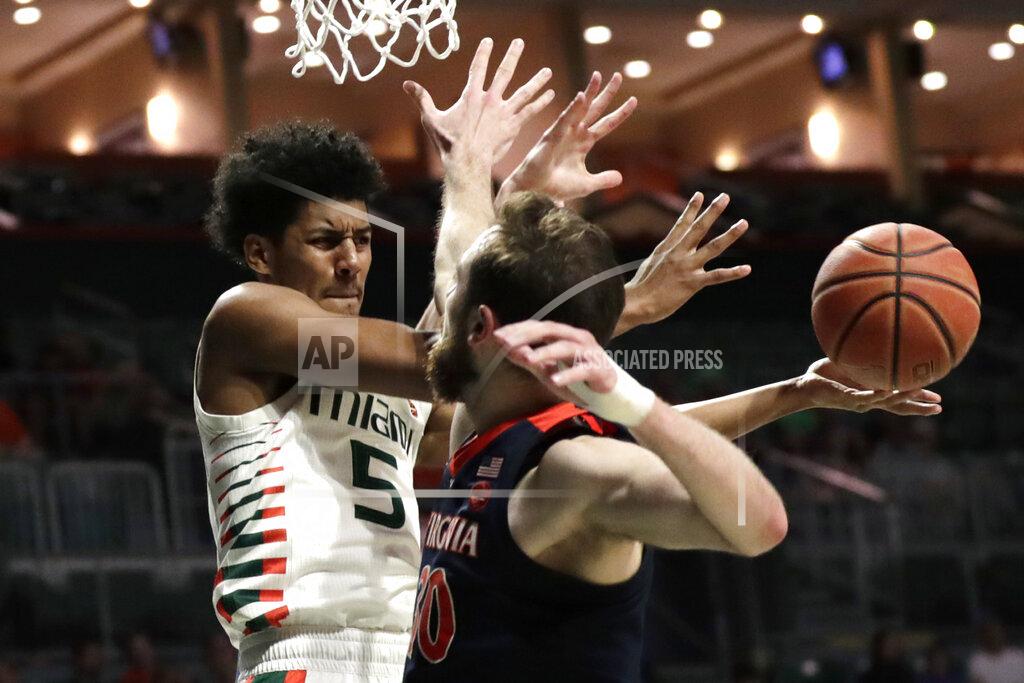 Lynne Sladky Miami guard Harlond Beverly (5) attempts to pass the ball as Virginia forward Jay Huff (30) defends during the second half of an NCAA college basketball game, Wednesday, March 4, 2020, in Coral Gables, Fla. Virginia won 46-44. (AP Photo/Lynne Sladky)