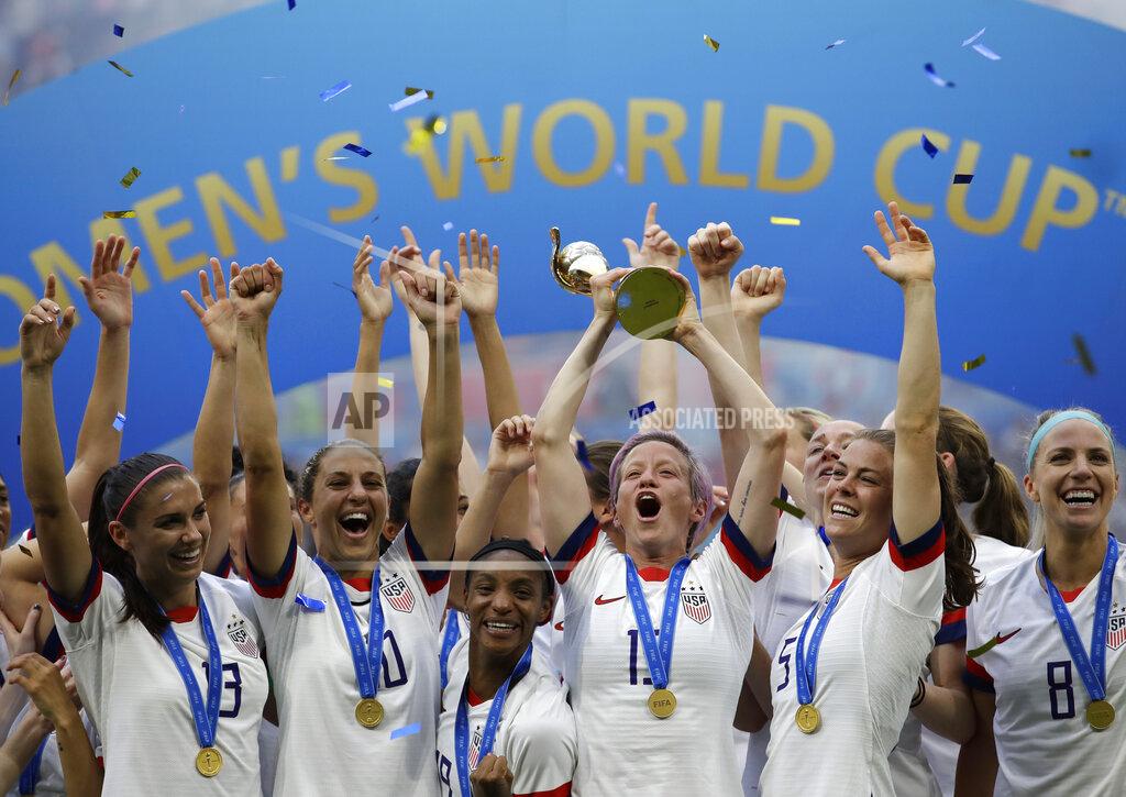 FILE - In this July 7, 2019, file photo, United States' Megan Rapinoe lifts up a trophy after winning the Women's World Cup final soccer match between US and The Netherlands at the Stade de Lyon in Decines, outside Lyon, France. The global players' association released its report on the state of women's soccer, after warning that the coronavirus outbreak could have a disastrous impact following the gains of last summer's Women's World Cup. (AP Photo/Alessandra Tarantino, File)