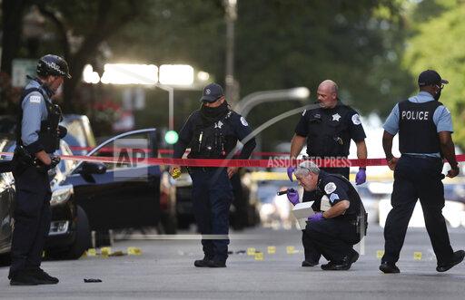 FILE - In this Aug. 4, 2020, file photo, Chicago police investigate the scene of a shooing in Chicago. Five alleged gang members have been indicted on murder charges in last year's shooting death of Chicago rapper Carlton Weekly, also known as "FBG Duck," in the fashionable Gold Coast neighborhood, that prosecutors say was part of an ongoing violent effort to protect gang territories on the city's South Side, officials announced Wednesday, Oct. 13, 2021. (Chris Sweda/Chicago Tribune via AP, File)