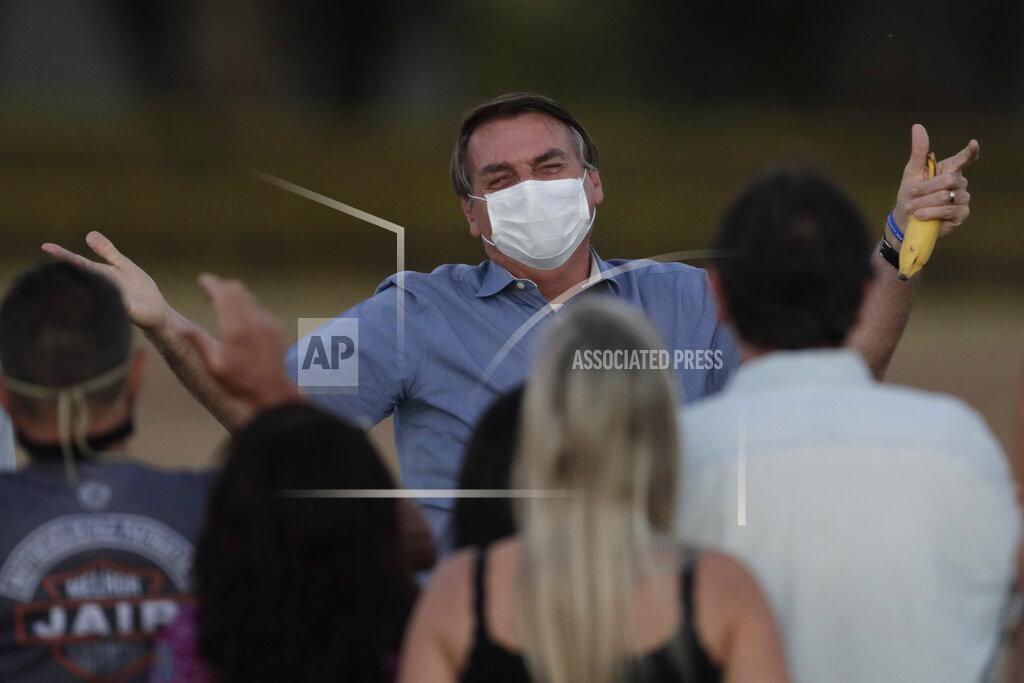 Eraldo Peres FILE - in this July 24, 2020 file photo, Brazil's President Jair Bolsonaro, who is infected with COVID-19, wears a protective face mask as he talks with supporters during a Brazilian flag retreat ceremony outside his official residence the Alvorada Palace, in Brasilia, Brazil. The South American nation proud of its role as a regional leader in science, technology and medicine, finds itself falling behind its neighbors in the global race for immunization against a pandemic that has already killed nearly 200,000 of its people. (AP Photo/Eraldo Peres, File)