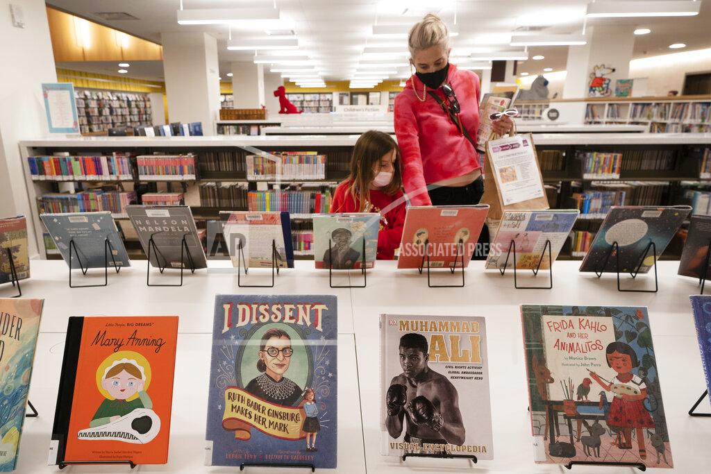 Mark Lennihan Zoe Slavin and her mother, Julie, browse for books in the children's section of the Stavros Niarchos Foundation Library, Tuesday, June 1, 2021 in New York. The city's central circulation library, closed for renovations in 2017, fully reopens today. It was previously called the Mid-Manhattan Library. (AP Photo/Mark Lennihan)