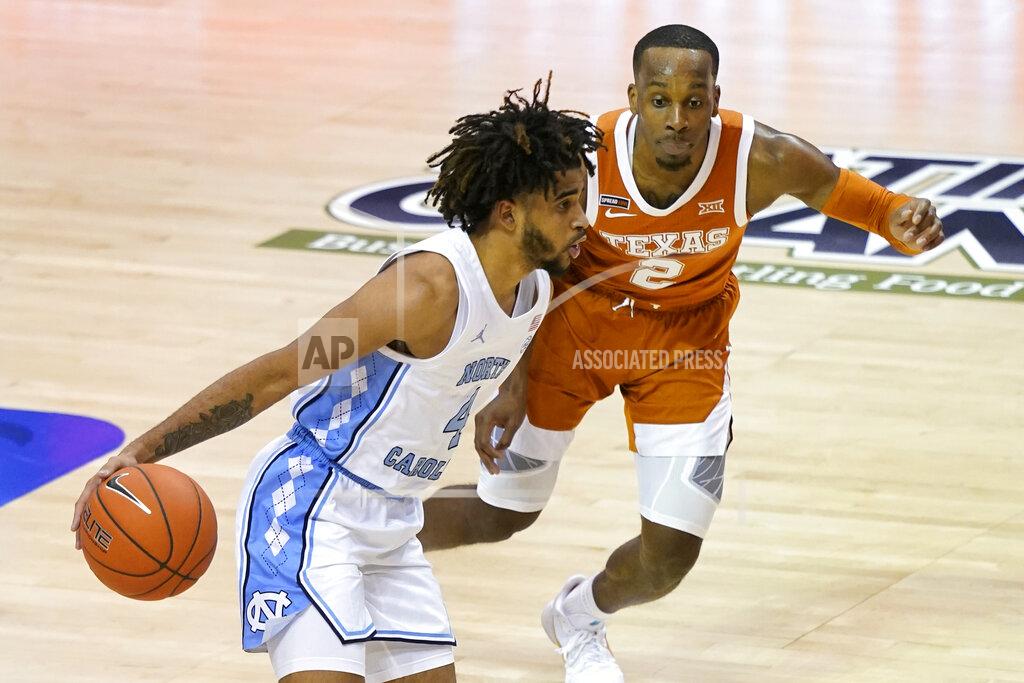 Kathy Kmonicek North Carolina guard R.J. Davis (4) drives the ball past Texas guard Matt Coleman III (2) in the second half of an NCAA college basketball game for the championship of the Maui Invitational, Wednesday, Dec. 2, 2020, in Asheville, N.C. Texas won 69-67. (AP Photo/Kathy Kmonicek)