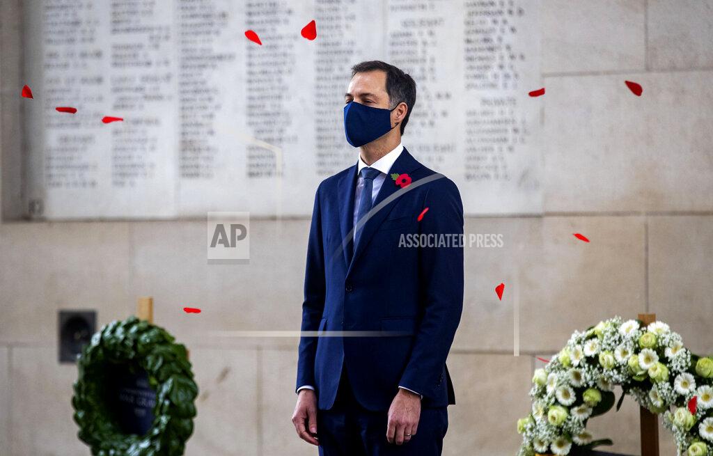 Kurt Desplenter Red paper poppies fall around Belgium's Prime Minister Alexander De Croo as he attends an Armistice Day ceremony at the Menin Gate Memorial to the Missing in Ypres, Belgium, Wednesday, Nov. 11, 2020. In a town usually crowded with visitors, coronavirus restrictions prevented the general public from attending a ceremony under the Menin Gate, with even dignitary attendance reduced to a minimum. (Kurt Desplenter, Pool via AP)