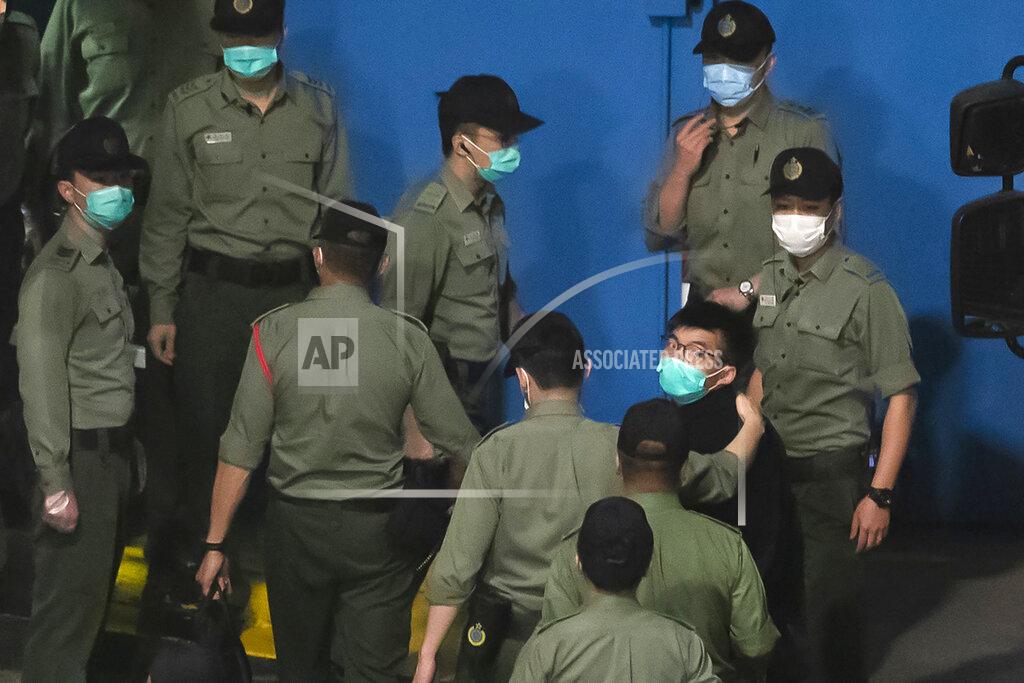 Kin Cheung FILE - In this Tuesday, March 2, 2021, file photo, Joshua Wong, right, one of the 47 pro-democracy Hong Kong activists, is escorted by Correctional Services officers to prison in Hong Kong, early Tuesday, March 2, 2021. In the semi-autonomous city of Hong Kong, China is moving to eliminate the possibility of opposition politicians gaining office, saying only patriots loyal to the Communist Party can have a role in government. (AP Photo/Kin Cheung, File)