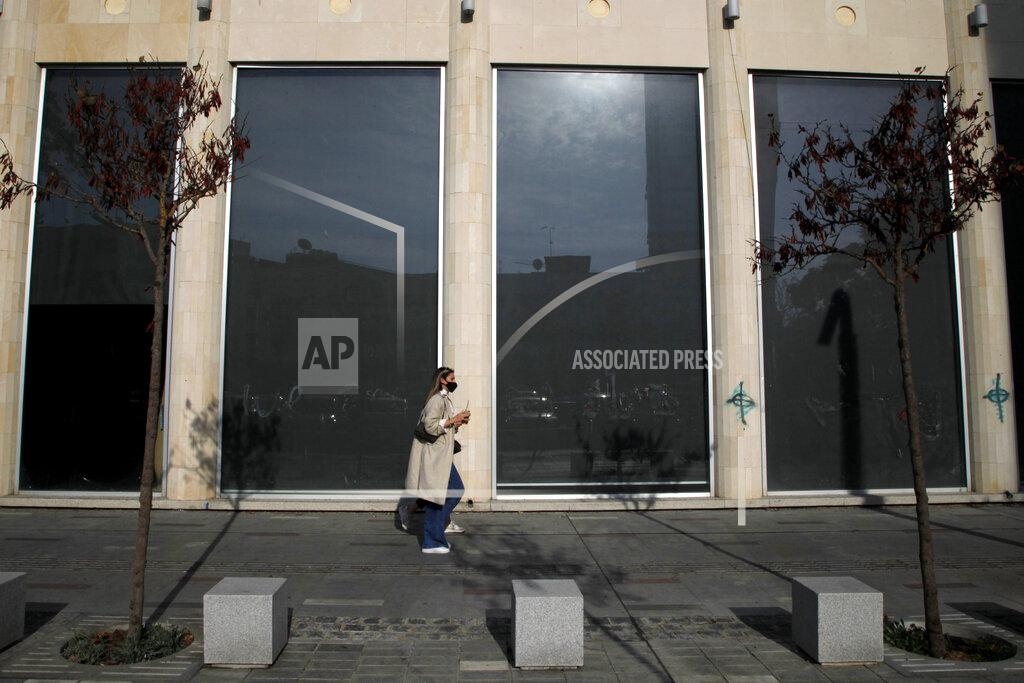 Petros Karadjias A woman wearing face mask walks at a shopping street in central Nicosia, Friday, Jan. 8, 2021. Cyprus is returning to lockdown mode for the remainder of the month with daytime restrictions on movement and a shuttering of schools after the country's health minister conceded that a raft of tough measures already in place including a night-time curfew weren't enough to curtail the spread of the coronavirus. (AP Photo/Petros Karadjias)