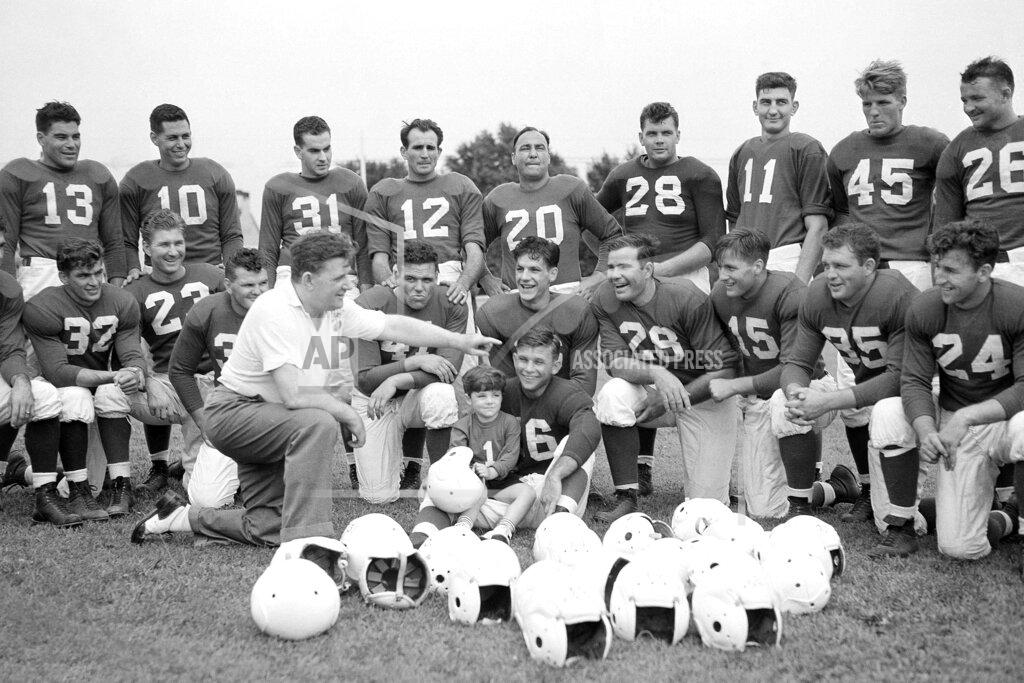 Uncredited FILE - In this July 26, 1939, file photo, Philadelphia Eagles owner and head coach Bert Bell talks to his squad as his son, Bert Bell Jr. sits on a players lap, in Philadelphia. Bell, who later became the league's commissioner, created the NFL draft as a way to assist teams who couldn't attract top talent in the free-for-all system that had been in place. (AP Photo/File)