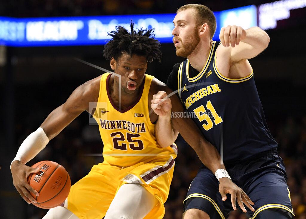 Hannah Foslien Michigan's Austin Davis (51) guards against Minnesota's Daniel Oturu (25) in the first half during an NCAA college basketball game on Sunday, Jan. 12, 2020, in Minneapolis. (AP Photo/Hannah Foslien)